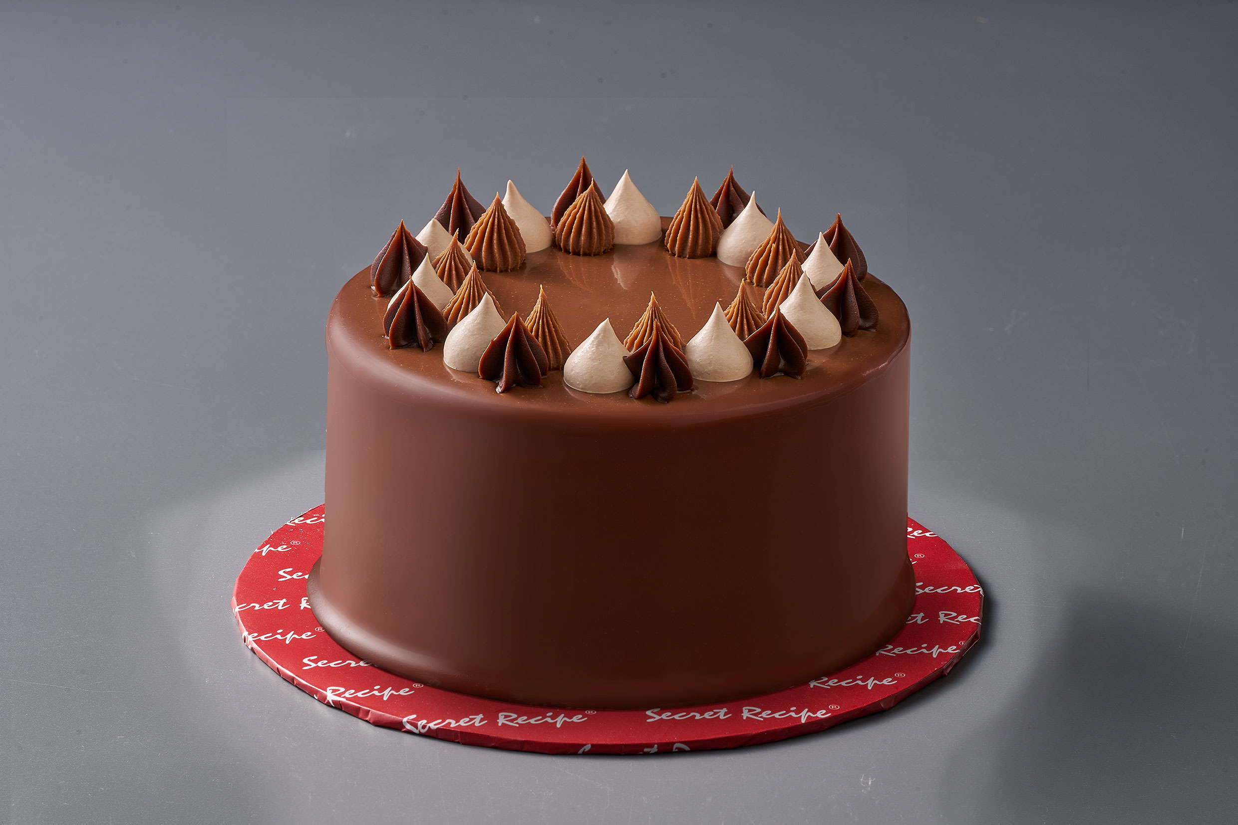 Secret Recipe Chocolat Au Lait birthday cake topped with cream swirls